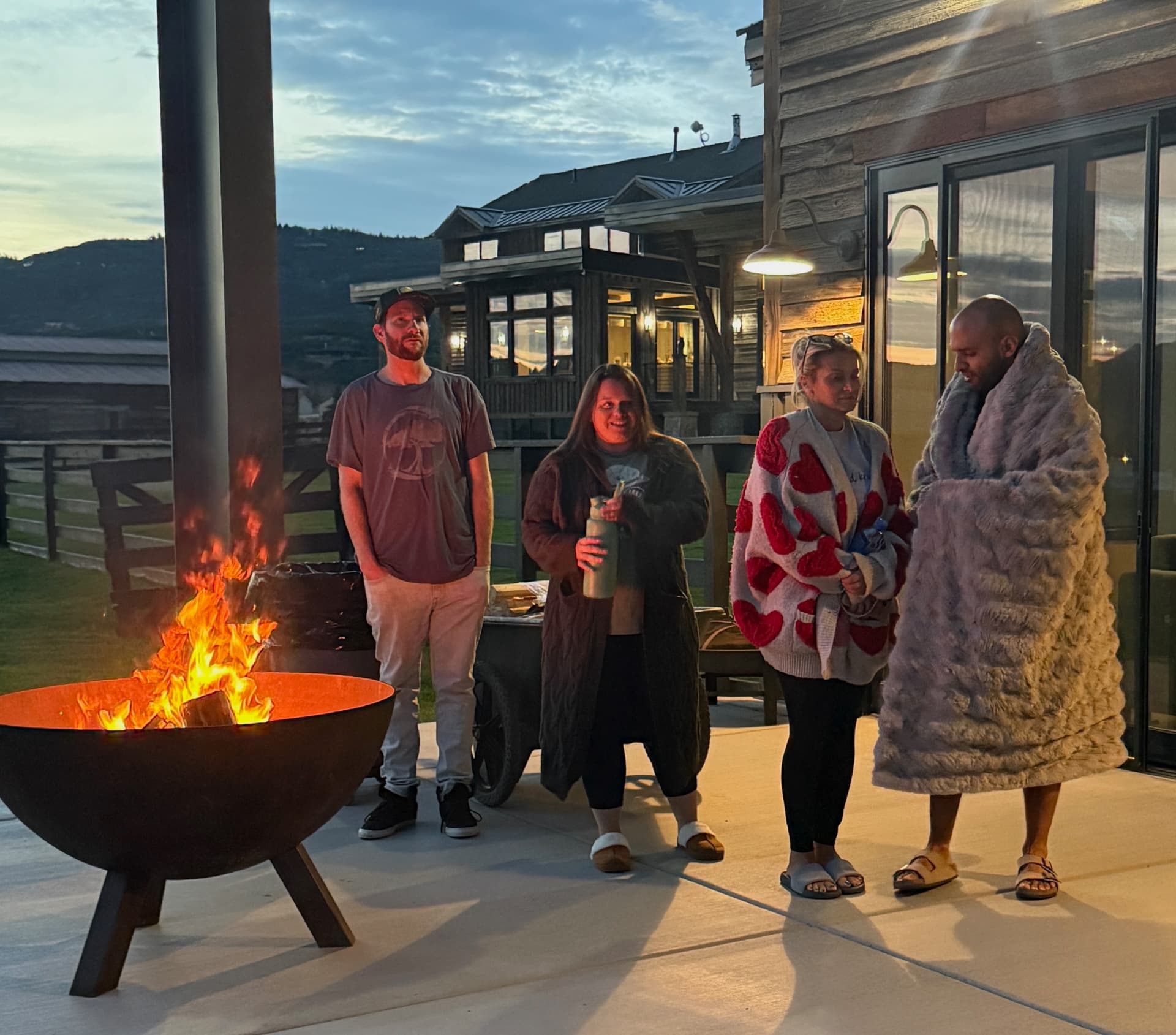 Participants gathered around the fire pit on the estate patio at dusk