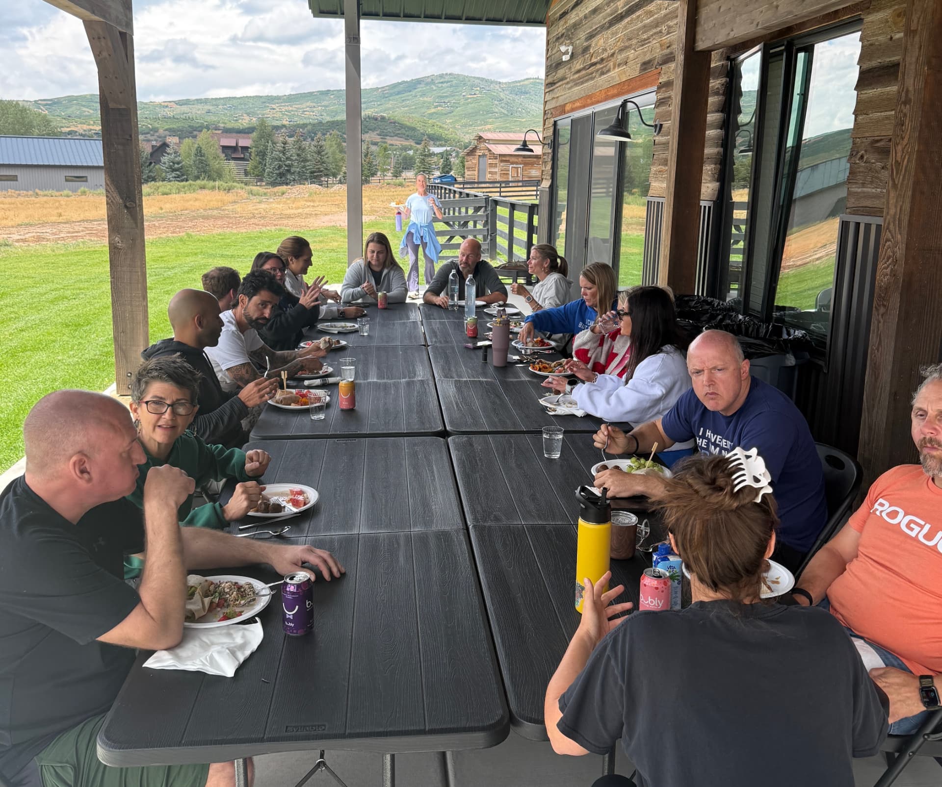 The group sharing a long-table meal on the covered patio