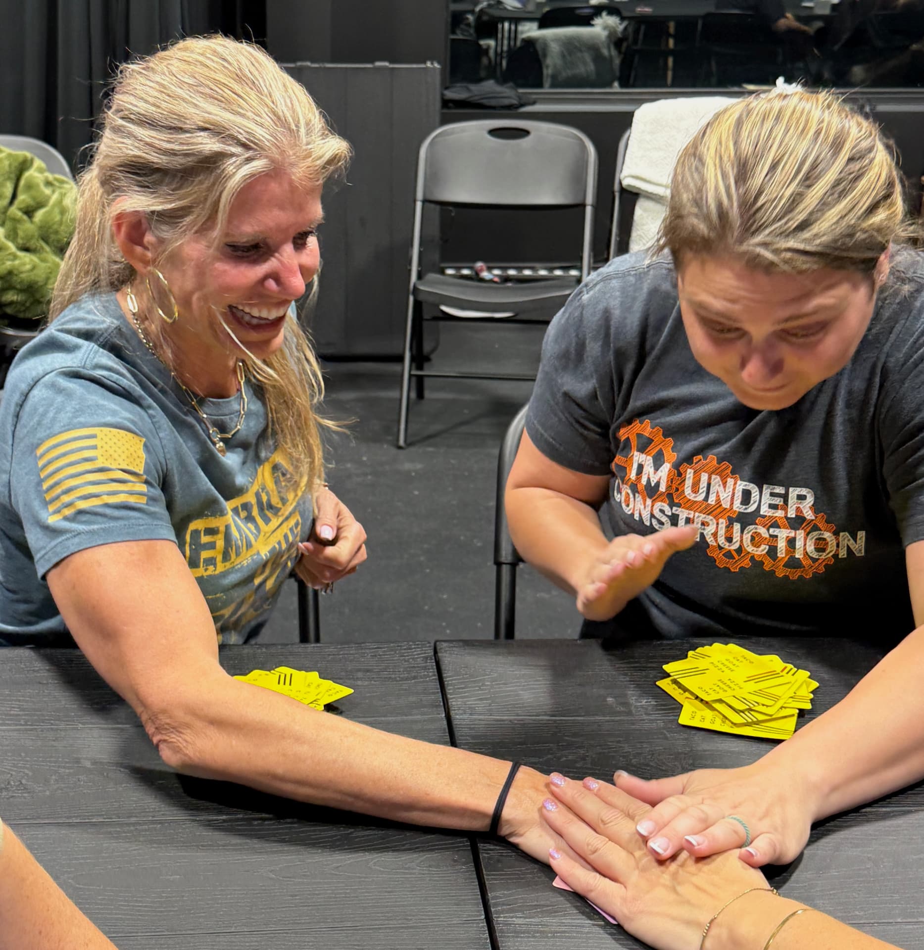 Two participants laughing together over an exercise at the table